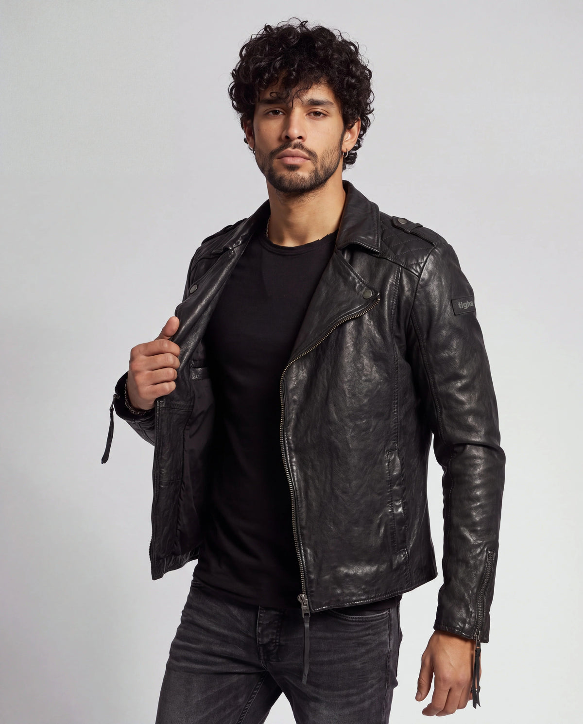 Elon von tigha – Perfecto-Biker-Lederjacke für Herren aus gewachstem Schafsleder mit Rautensteppung, offen getragen, Hand am Revers
